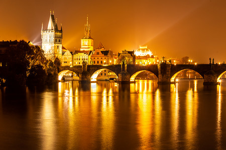 伏尔塔瓦河和查理大桥与旧城桥塔在夜间，布拉格，捷克。