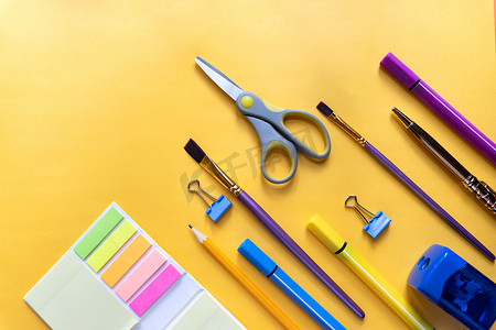 黄色趋势背景、空间或文字平躺的彩色固定学校用品。各种学校用品。回到学校概念