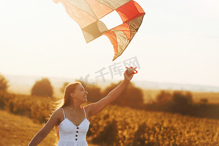 夏日在田野上玩风筝的快乐女人，微笑着