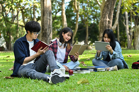 一群学生阅读书籍，准备在大学校园的绿色草坪上考试。