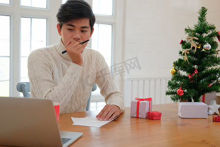 男人在想在圣诞贺卡上写什么圣诞装饰的节日祝福