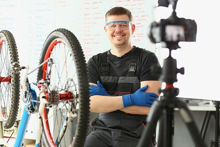 工头摄影照片_微笑的工头在相机上拍下修理自行车的照片