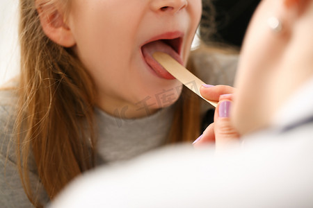 健康摄影照片_耳鼻喉科医生检查喉咙痛的女童