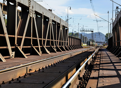从旧铁路桥看，锈迹斑斑、铁轨、电缆和电线杆在远处可见。