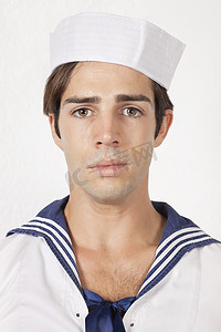 灰色背景下身穿水手制服的悲伤年轻人画像