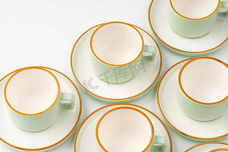 一套带橙色轮廓的白色和淡绿色陶瓷茶杯