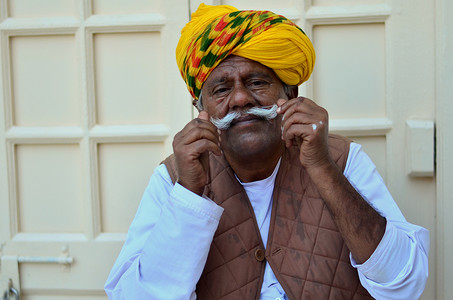 印度拉贾斯坦邦焦特布尔，大约 2020 年。一位老人兼守门人戴着黄色彩色头巾，在梅兰加尔堡炫耀他的胡子。