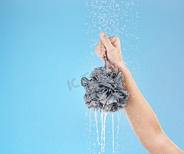 洗澡女人摄影照片_蓝色背景模拟工作室中女人的淋浴、丝瓜络和手。