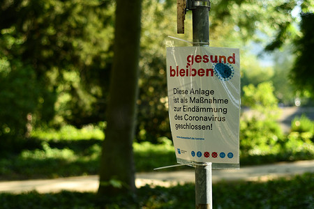 安全提示提示摄影照片_保持健康 在德国杜塞尔多夫的一个公园里，通过提示和规则与 Covied-19 签约