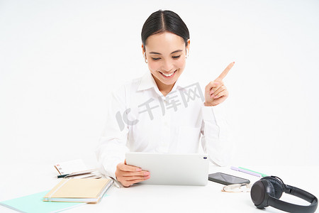 成功女性员工的肖像，亚洲女性通过数字平板电脑进行视频聊天，坐在办公室里与客户进行在线会议，白色背景