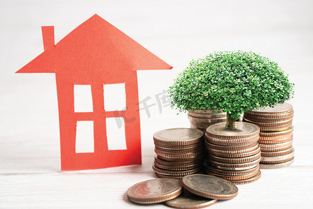 房屋模型，在硬币钱、房屋贷款、储蓄计划、分期付款金融和银行概念上种植植物。