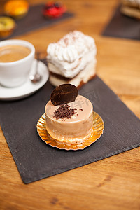 咖啡店木桌上放着棕色釉料和美味饼干的美味蛋糕