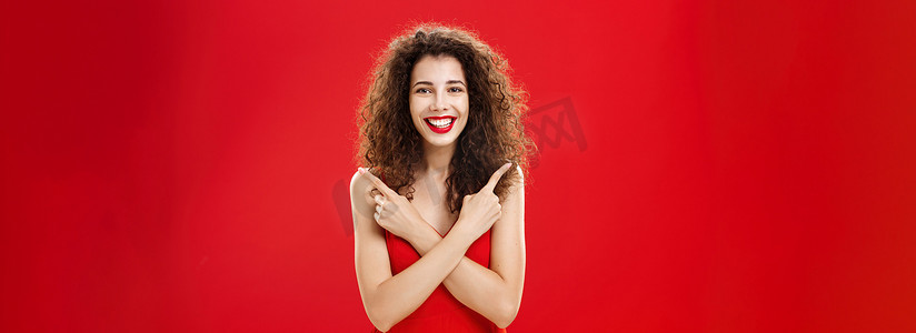红色晚礼服摄影照片_女人对任何决定感到满意，穿着优雅的红色晚礼服，手挽手交叉在胸前，左指右指，高兴地选择