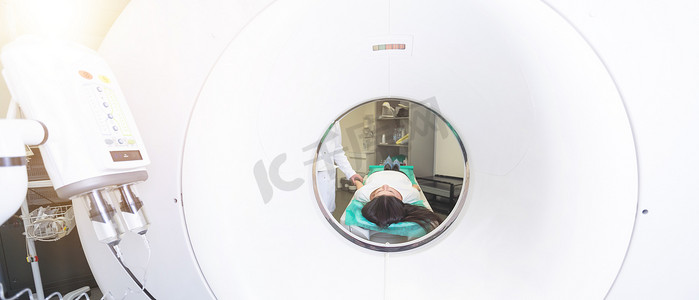断层扫描仪摄影照片_放射科医生和一位女性患者在计算机断层扫描室。