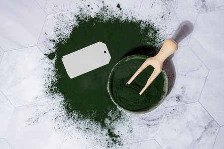功能食品摄影照片_碗中蓝绿藻小球藻和螺旋藻粉，空纸条模拟复制空间。