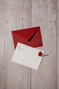 邀请卡设计摄影照片_问候卡或邀请卡模拟与木制背景上的红色信封。