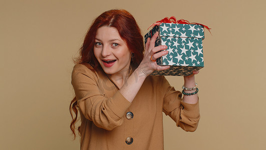 礼盒拆开摄影照片_快乐的女人打开礼盒，打开生日惊喜，表达极大的幸福惊奇