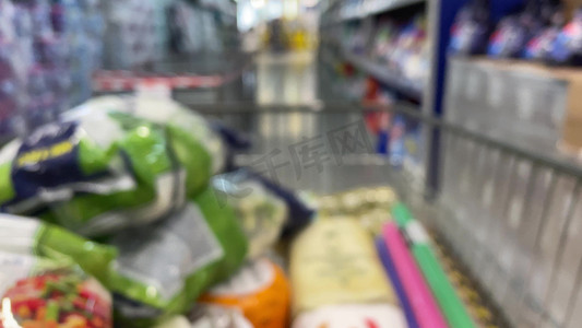 从购物车看超市里的手推车，焦点不在与在超市货架上选择产品的面目全非的人。