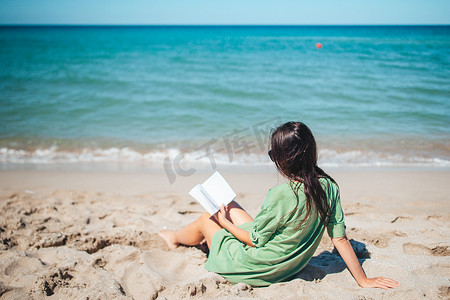 海边女子摄影照片_年轻女子在热带白色海滩读书