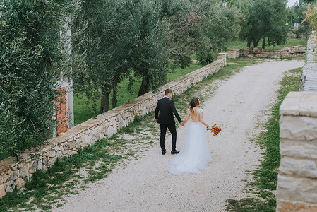 幸福时尚微笑的夫妇在婚礼当天在意大利托斯卡纳散步。