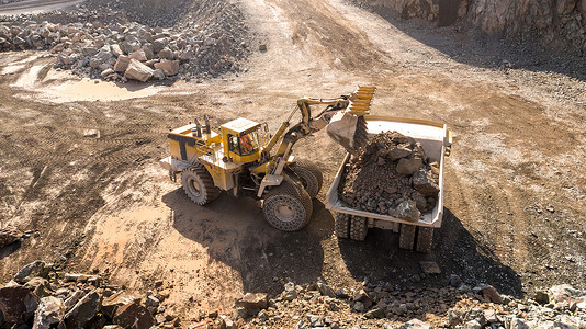 在采石场工作的挖掘机和自卸卡车采矿