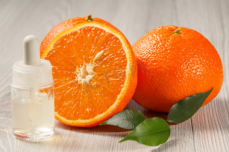 香薰瓶摄影照片_用两个完整的橙子切橙子，然后用香薰油装瓶