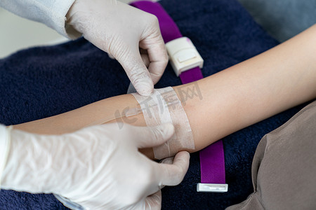 医生手把静脉内 (IV) 注射放在病人手臂上进行 dri