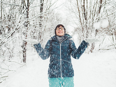 微笑的女人正在玩雪。