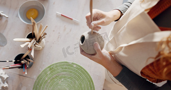 在艺术工作室、产品制造车间或小型企业中，手、陶泥或雕塑艺术家用粘土杯、杯子或花瓶。