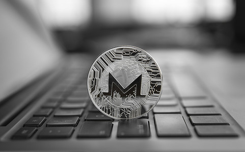 monero摄影照片_笔记本电脑上的 Monero 硬币符号，未来概念金融货币，加密货币符号。