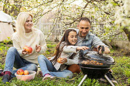 幸福的家庭在春天的花园里烧烤。
