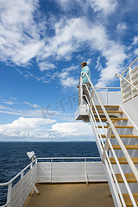 渡轮上身穿蓝色毛衣的成年女性，蓝天白云
