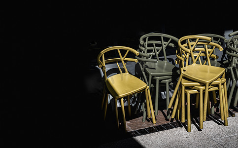 一堆深绿色（卡其色）和黄色塑料椅子的细节。