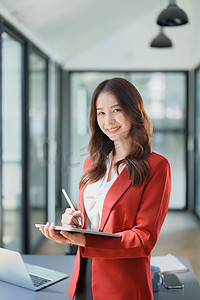 企业主或亚洲女性营销人员在办公室工作中使用平板电脑