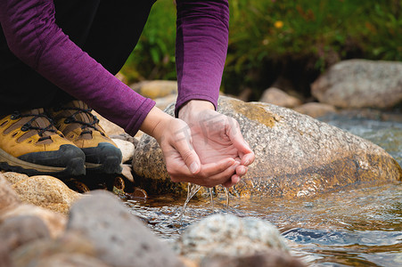 健康水源摄影照片_女手特写从山涧汲水解渴，喝干净的水源。