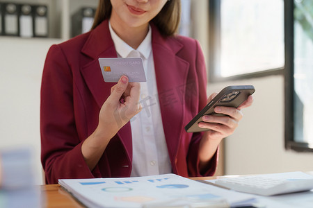 使用智能手机和信用卡进行在线购物的亚洲女性。