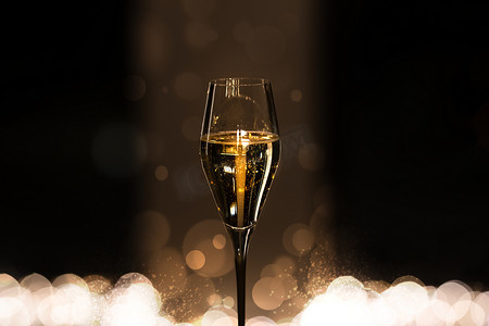 一杯香槟与散景的深色背景上的气泡。