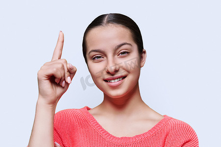 快乐的年轻女人在白色背景中竖起食指
