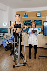 中心化验室摄影照片_适合女性测试步进器和医生在平板电脑上做笔记