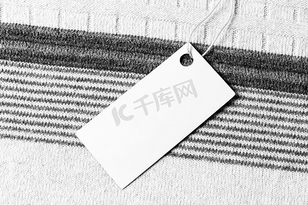 理货摄影照片_羊毛织物上的白色标签。