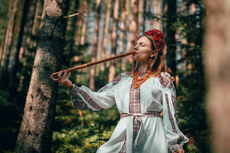 在木笛上演奏的女人-在森林背景下的乌克兰 telenka tylynka。