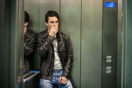 害怕的年轻人绝望地困在电梯里