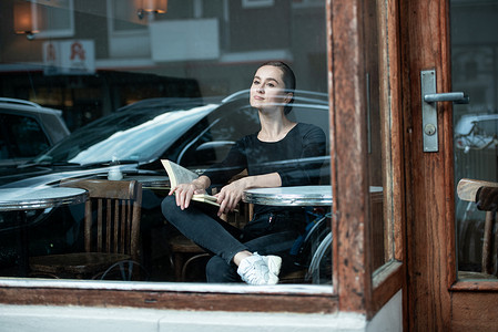 人群交谈摄影照片_女人在咖啡店看书喝咖啡看书