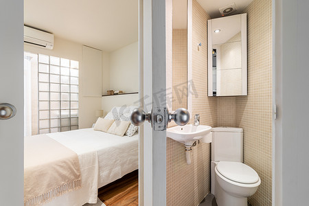 从带米色瓷砖马桶和水槽的浴室到带床和玻璃砖墙的卧室。