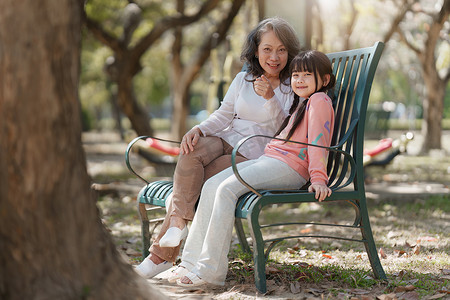 亚洲祖母和孙女一起在户外公园活动。