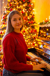 弹钢琴时穿着鲜红色毛衣的年轻女孩的画像