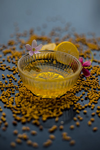 著名的天然头皮屑在玻璃碗中的木制表面上的方法由胡芦巴种子粉与柠檬汁充分混合而成。表面上有生柠檬和胡芦巴种子。