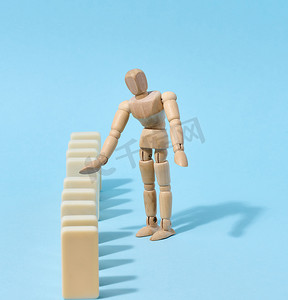 木制玩具人体模型防止多米诺骨牌掉落，风险预防概念