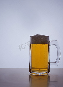 一个啤酒杯的剪影，里面装着琥珀色的黄色啤酒，里面倒着泡沫