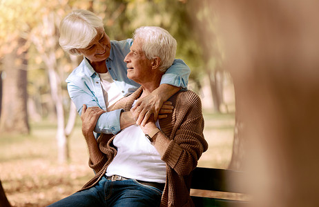 爱，老年夫妇在公园的长椅上拥抱，在户外结合和浪漫。